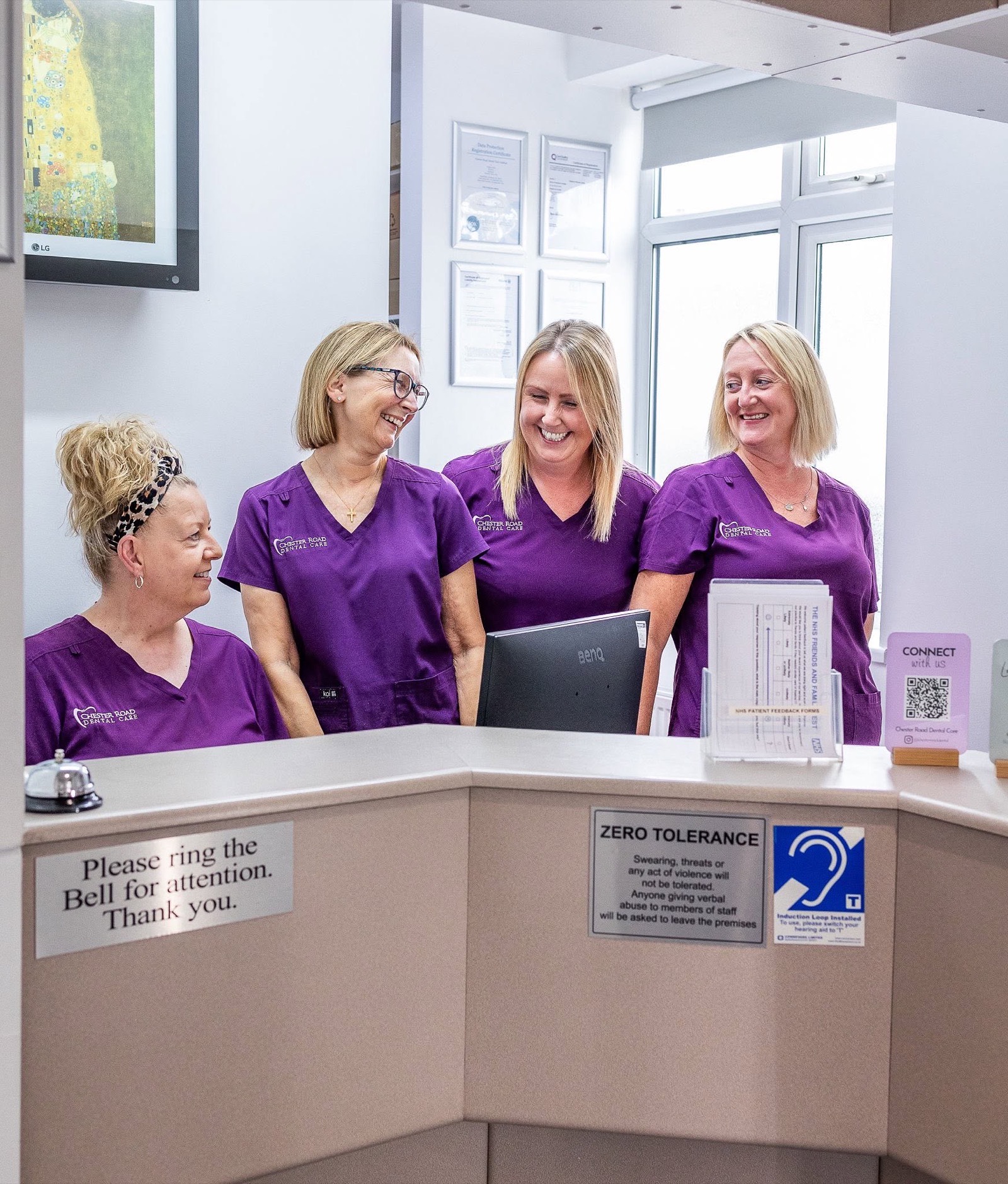 The reception team smiling together at the front desk