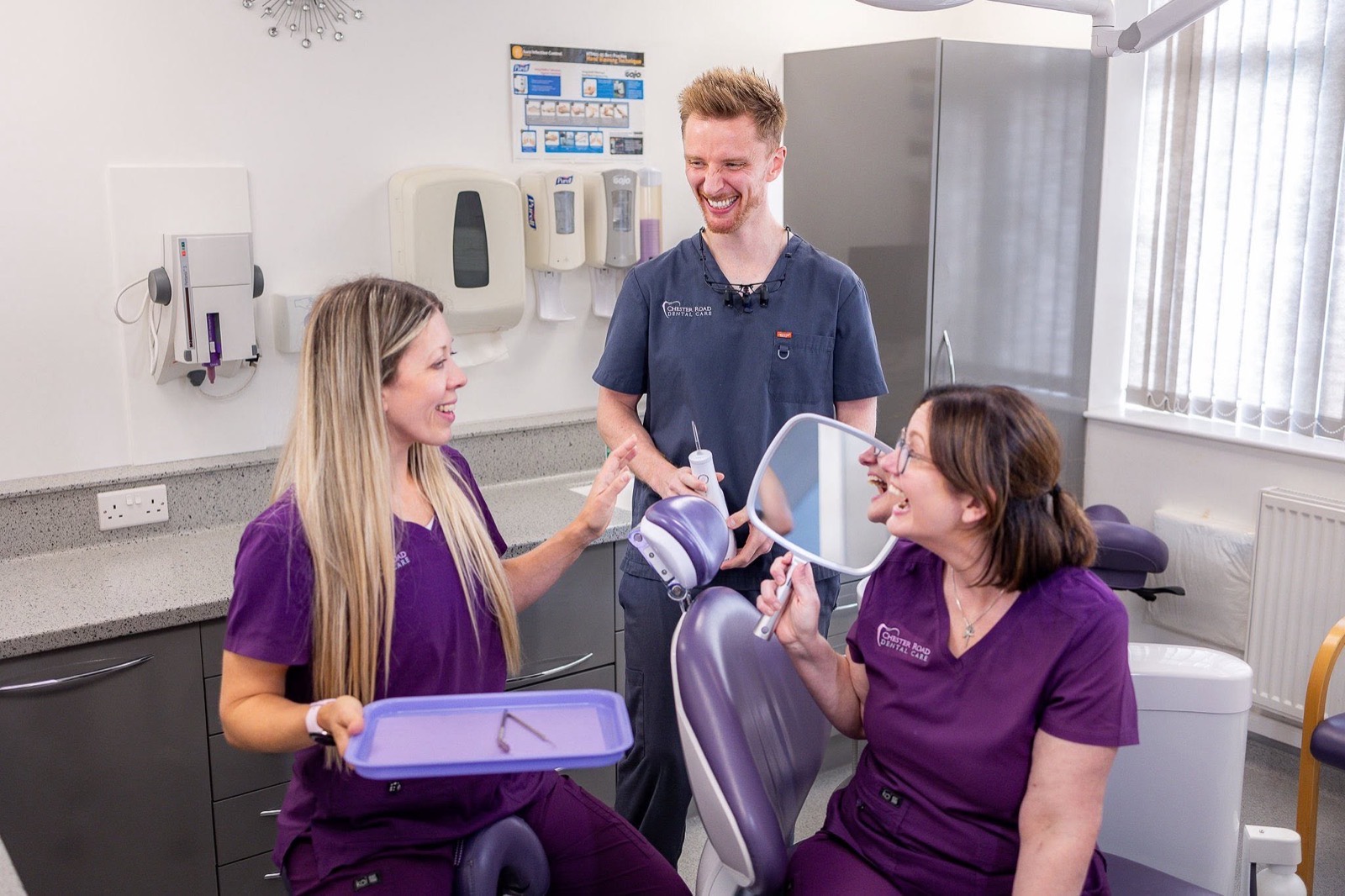 Dentists and nurses laughing together in a modern treatment room